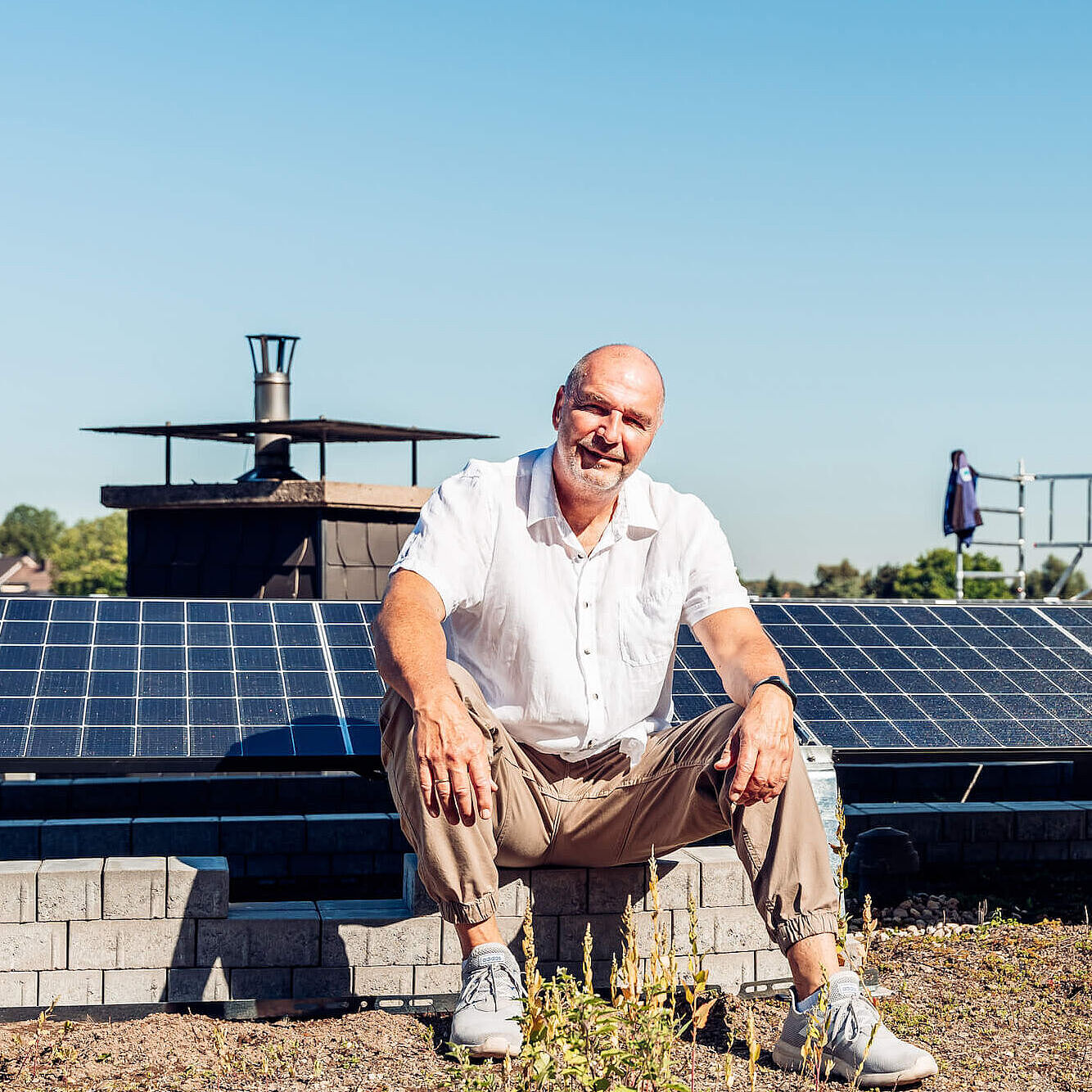 Dirk Wiese auf seinem Dach. Im Hintergrund sind die Solaranlagen zu sehen.