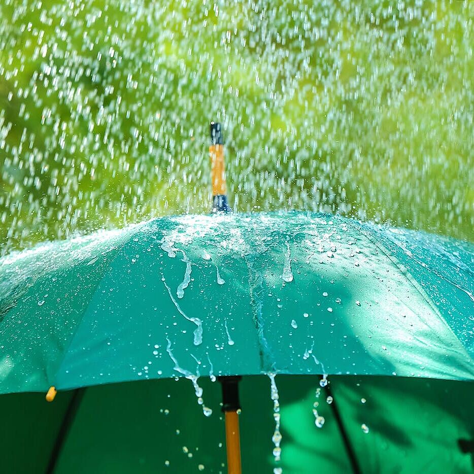 Aufgespannter Regenschirm im Regen.